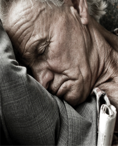 Older gentleman sleeping with his arm angled up around his head.
